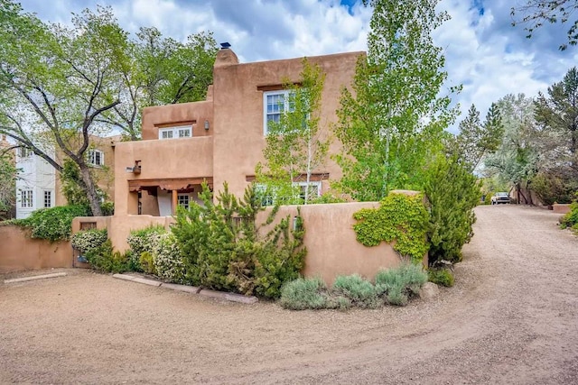 334 Otero Unit 14-3, Santa Fe, NM 87501 - view of front of home with fence, a chimney, and stucco siding