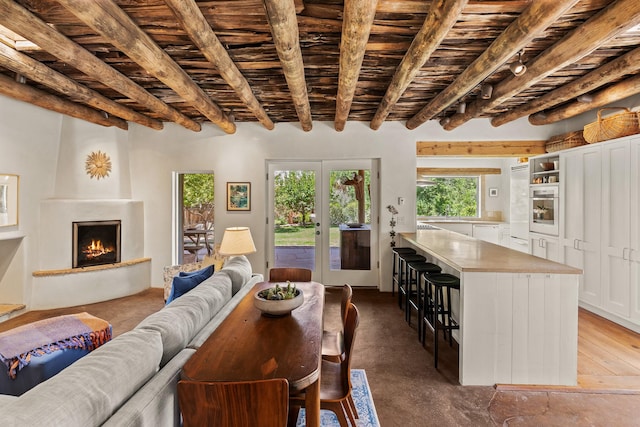 127 County Road 84, Santa Fe, NM 87506 - living room featuring beamed ceiling, a large fireplace, wooden ceiling, and finished concrete floors