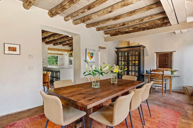 127 County Road 84, Santa Fe, NM 87506 - dining space featuring wood ceiling, beam ceiling, and concrete flooring