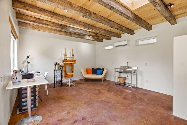 127 County Road 84, Santa Fe, NM 87506 - sitting room featuring a wall mounted air conditioner, wooden ceiling, finished concrete flooring, and beam ceiling