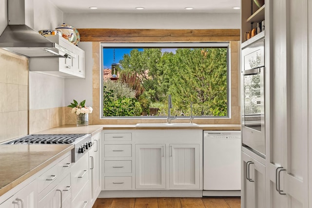 127 County Road 84, Santa Fe, NM 87506 - kitchen featuring white dishwasher, wall chimney range hood, a sink, plenty of natural light, and recessed lighting