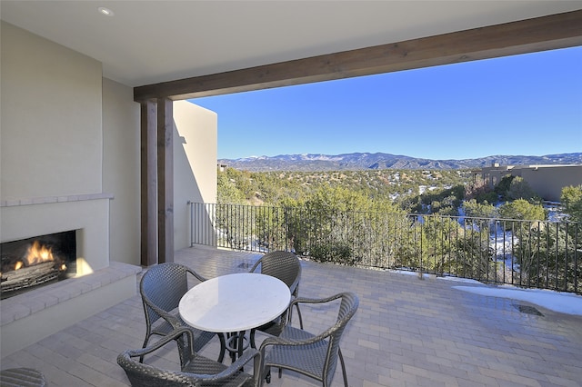 3289 Monte Sereno, Santa Fe, NM 87506 - view of patio / terrace featuring a lit fireplace and a mountain view