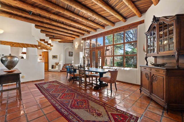 17 Tano W, Santa Fe, NM 87506 - dining area featuring wood ceiling with exposed beams, arched walkways, tile patterned flooring, and stairs