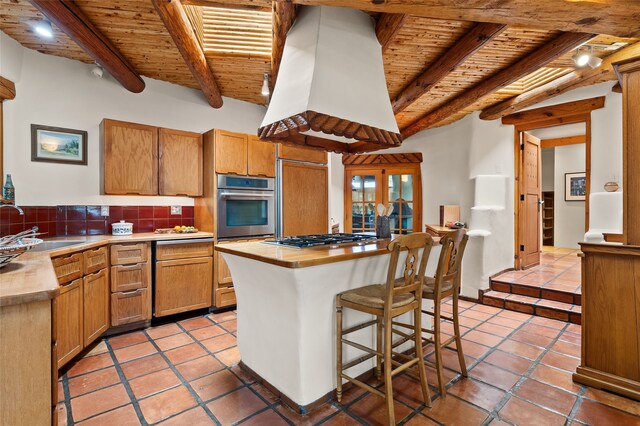 17 Tano W, Santa Fe, NM 87506 - kitchen with wooden ceiling with exposed beams, a sink, stainless steel appliances, tasteful backsplash, and light tile patterned flooring