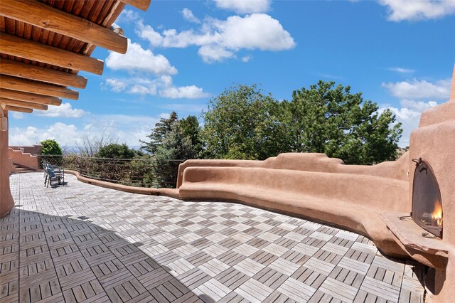 17 Tano W, Santa Fe, NM 87506 - view of patio / terrace featuring a lit fireplace
