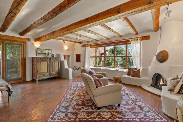 17 Tano W, Santa Fe, NM 87506 - living room with plenty of natural light, beamed ceiling, and a large fireplace