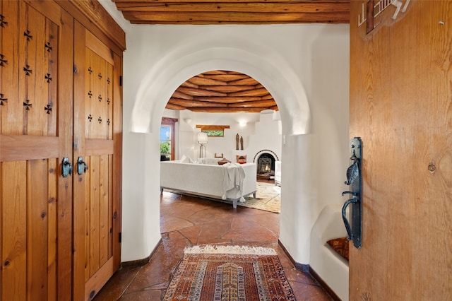 17 Tano W, Santa Fe, NM 87506 - entrance foyer with arched walkways, stone tile flooring, baseboards, and beam ceiling