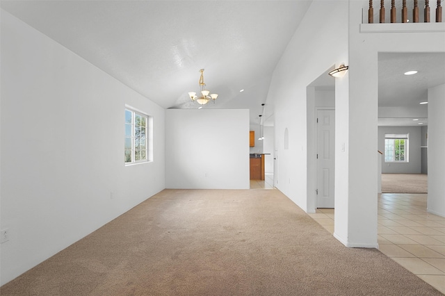 1905 Mendius, Los Alamos, NM 87544 - unfurnished living room featuring light carpet, a chandelier, light tile patterned flooring, recessed lighting, and high vaulted ceiling