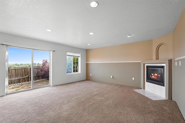 1905 Mendius, Los Alamos, NM 87544 - unfurnished living room featuring carpet flooring, a tiled fireplace, a textured ceiling, and recessed lighting