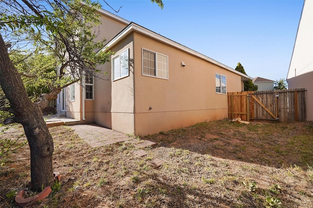 1905 Mendius, Los Alamos, NM 87544 - view of home's exterior featuring a patio area, a gate, and stucco siding