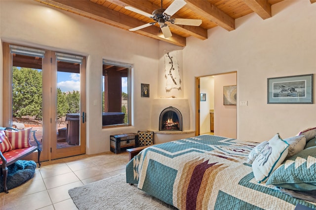 2 Tierra Grande, Santa Fe, NM 87506 - tiled bedroom featuring wooden ceiling with exposed beams, access to exterior, and a fireplace