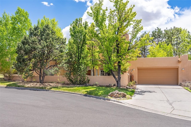 3101 Old Pecos Trl Unit 628, Santa Fe, NM 87505 - pueblo-style house featuring concrete driveway, stucco siding, and an attached garage