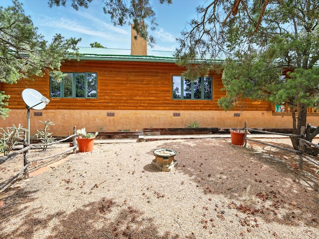 125 Apache Canyon Trl, Santa Fe, NM 87505 - back of house with crawl space, metal roof, a chimney, and log siding