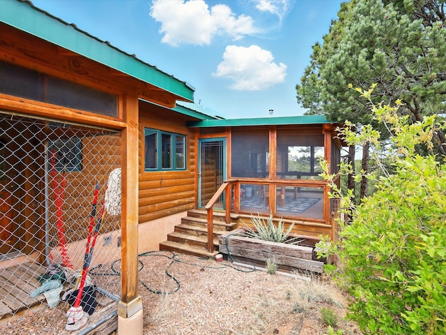 125 Apache Canyon Trl, Santa Fe, NM 87505 - rear view of house with log veneer siding, metal roof, and a sunroom