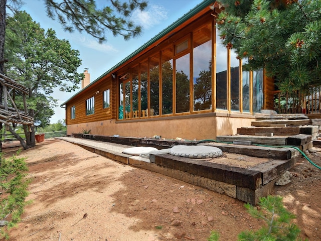 125 Apache Canyon Trl, Santa Fe, NM 87505 - view of property exterior featuring a sunroom and a chimney