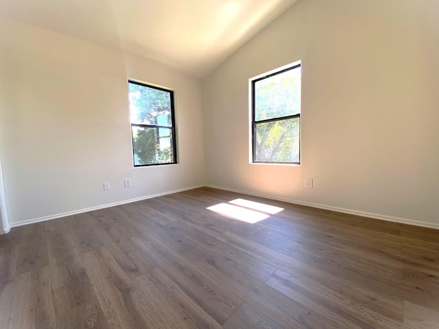 421 Maple Ave, Chama, NM 87520 - empty room featuring plenty of natural light, vaulted ceiling, dark wood-type flooring, and baseboards