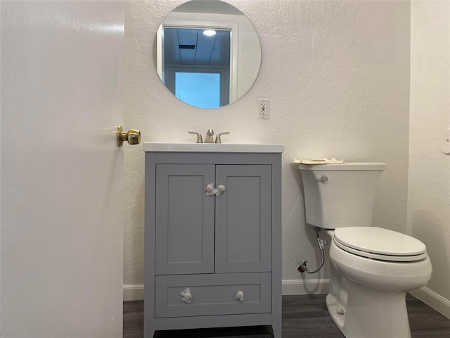 421 Maple Ave, Chama, NM 87520 - half bathroom featuring vanity, baseboards, toilet, and wood finished floors