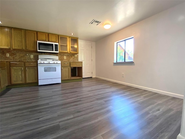 421 Maple Ave, Chama, NM 87520 - kitchen featuring white gas stove, baseboards, dark wood-style floors, backsplash, and brown cabinetry