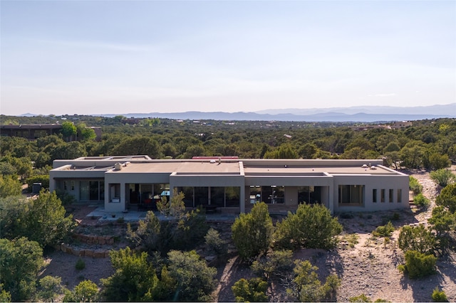 26 San Juan Ranch Rd, Santa Fe, NM 87506 - back of property with stucco siding, a mountain view, a patio, and a view of trees