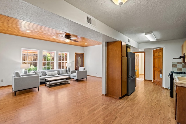 1024 Camino Vista Aurora, Santa Fe, NM 87507 - living area with light wood finished floors, a ceiling fan, baseboards, and a textured ceiling