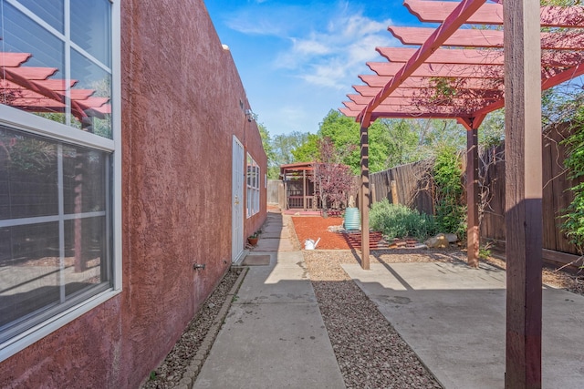 1024 Camino Vista Aurora, Santa Fe, NM 87507 - view of home's exterior featuring stucco siding, a fenced backyard, a patio, and a pergola