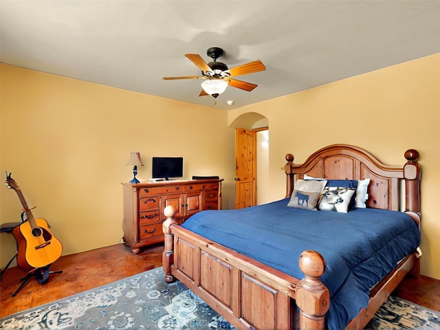 488 Old Denver Hwy, Glorieta, NM 87535 - bedroom featuring concrete flooring, arched walkways, and a ceiling fan
