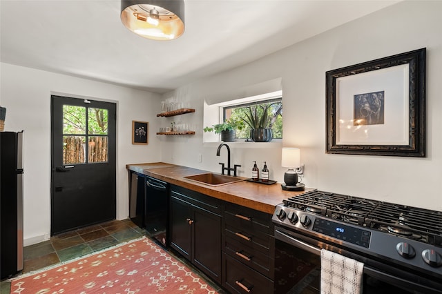 824 Dunlap St Unit A, Santa Fe, NM 87501 - kitchen with appliances with stainless steel finishes, a sink, dark stone finish flooring, open shelves, and dark cabinetry