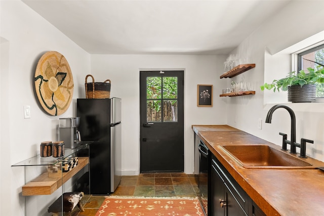824 Dunlap St Unit A, Santa Fe, NM 87501 - kitchen featuring freestanding refrigerator, a sink, black dishwasher, dark stone finish flooring, and baseboards