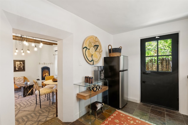 824 Dunlap St Unit A, Santa Fe, NM 87501 - kitchen featuring freestanding refrigerator, stone tile floors, baseboards, and a large fireplace