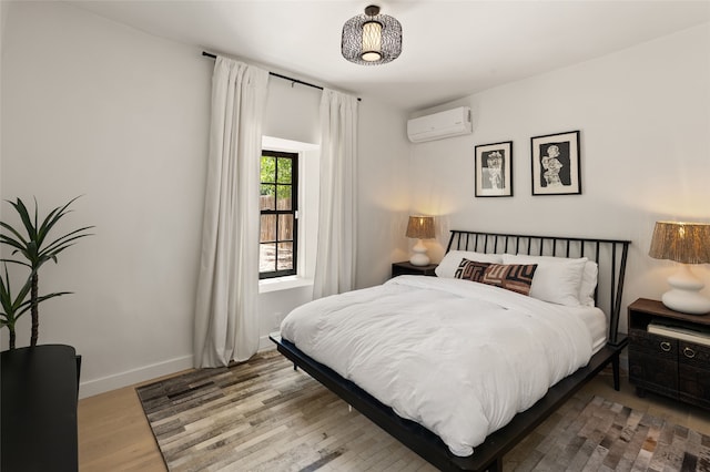 824 Dunlap St Unit A, Santa Fe, NM 87501 - bedroom featuring a wall mounted AC, wood finished floors, and baseboards