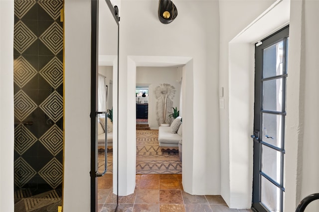 824 Dunlap St Unit A, Santa Fe, NM 87501 - foyer featuring stone finish flooring, an accent wall, and a barn door