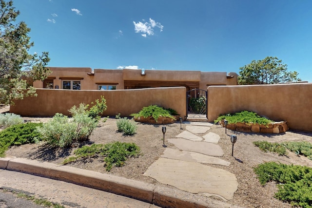 425 Calle Kokopelli, Santa Fe, NM 87501 - view of front of home with a fenced front yard, a gate, and stucco siding