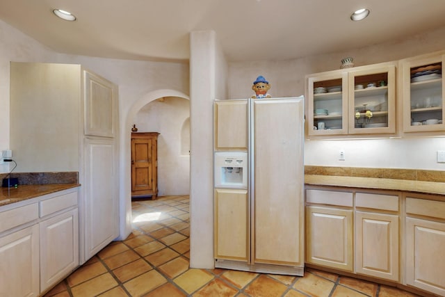 425 Calle Kokopelli, Santa Fe, NM 87501 - kitchen featuring paneled refrigerator, arched walkways, glass insert cabinets, light tile patterned flooring, and recessed lighting