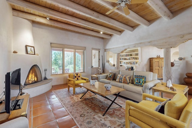 425 Calle Kokopelli, Santa Fe, NM 87501 - living area featuring wood ceiling with exposed beams, tile patterned floors, ceiling fan, and a large fireplace