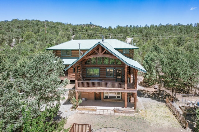76 Los Altos De Cicuye, Pecos, NM 87552 - rear view of property with a forest view, log exterior, a patio area, and metal roof