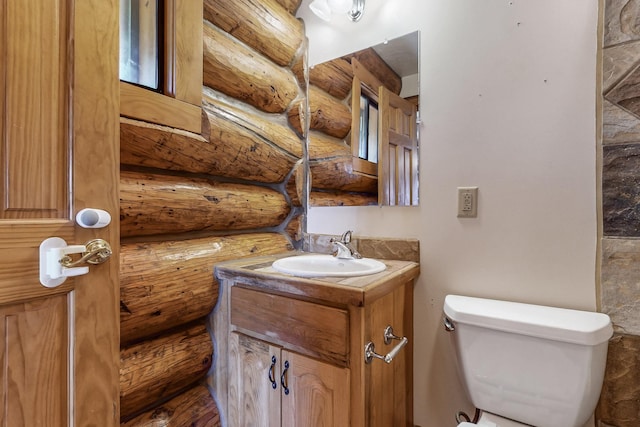 76 Los Altos De Cicuye, Pecos, NM 87552 - half bathroom with vanity, rustic walls, and toilet