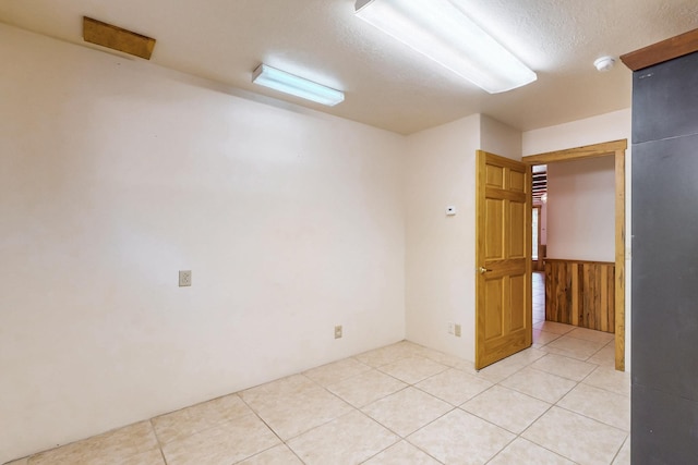 76 Los Altos De Cicuye, Pecos, NM 87552 - unfurnished room featuring wainscoting, a textured ceiling, light tile patterned flooring, and a smoke detector