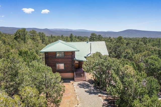 76 Los Altos De Cicuye, Pecos, NM 87552 - view of front of home with log siding, metal roof, a forest view, and a mountain view