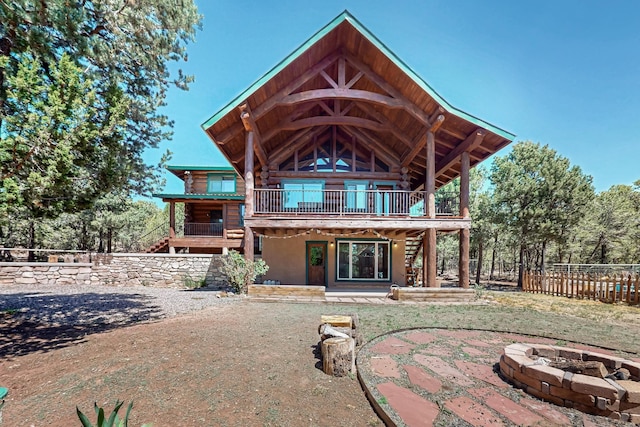 76 Los Altos De Cicuye, Pecos, NM 87552 - rear view of property with log siding, an outdoor fire pit, stairway, and a patio area