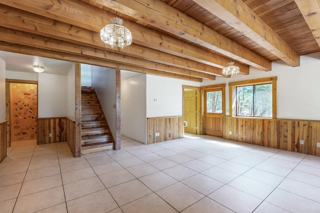 76 Los Altos De Cicuye, Pecos, NM 87552 - unfurnished living room with a chandelier, a wainscoted wall, wooden walls, stairway, and wood ceiling with exposed beams
