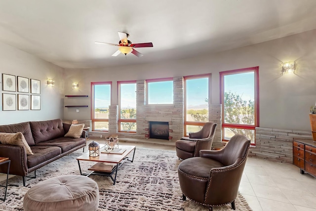 5 La Aguapa, Sandia Park, NM 87047 - living area featuring a ceiling fan, a fireplace with raised hearth, and light tile patterned floors