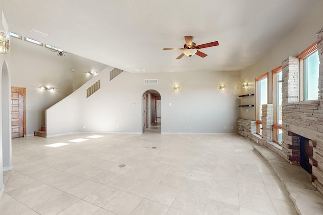 5 La Aguapa, Sandia Park, NM 87047 - unfurnished living room featuring arched walkways, a ceiling fan, light tile patterned floors, and baseboards