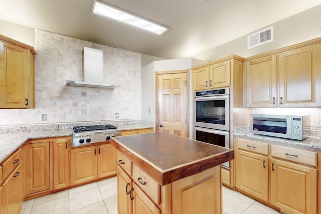 5 La Aguapa, Sandia Park, NM 87047 - kitchen with appliances with stainless steel finishes, wall chimney exhaust hood, backsplash, light tile patterned floors, and light brown cabinets