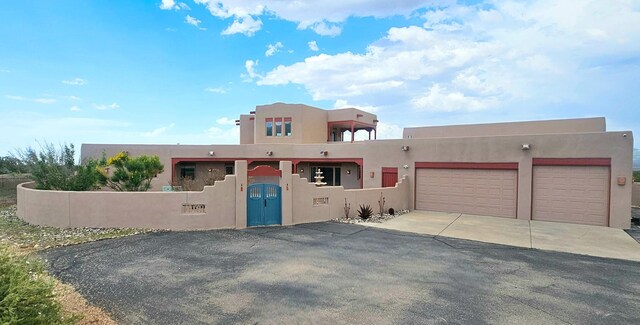 5 La Aguapa, Sandia Park, NM 87047 - adobe home with driveway, an attached garage, stucco siding, and a fenced front yard