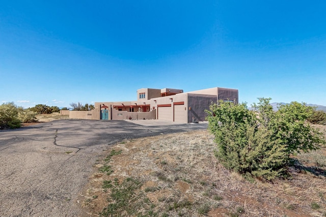 5 La Aguapa, Sandia Park, NM 87047 - adobe home featuring driveway, a garage, and stucco siding