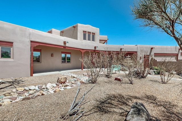 5 La Aguapa, Sandia Park, NM 87047 - rear view of house with stucco siding and a patio area