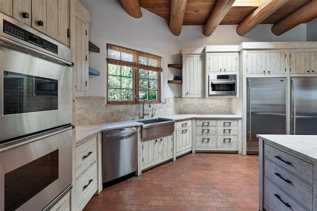 1050 Sierra Del Norte, Santa Fe, NM 87501 - kitchen featuring stainless steel appliances, open shelves, a sink, brick flooring, and light countertops