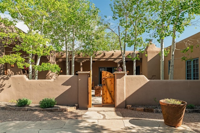 1050 Sierra Del Norte, Santa Fe, NM 87501 - southwest-style home featuring a fenced front yard, a gate, and stucco siding