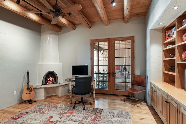 1050 Sierra Del Norte, Santa Fe, NM 87501 - office area featuring wood ceiling with exposed beams, french doors, light wood-style floors, ceiling fan, and a large fireplace