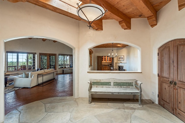 1050 Sierra Del Norte, Santa Fe, NM 87501 - foyer entrance with arched walkways, wooden ceiling with exposed beams, and a chandelier